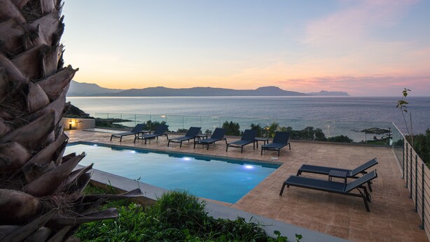 An infinity pool with lounge chairs and a view of the sea at sunset. - Pietra Di Mare (Rethymno)