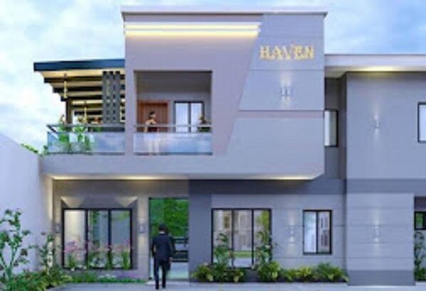 A modern hotel with a prominent 'HAYEN' sign, featuring a two-story structure with large windows and a balcony.