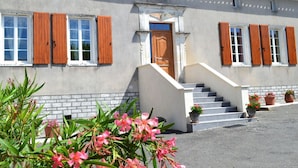 A two-story building with a central entrance, a staircase, and a tiled roof. - Renovated Charente cottage with vineyard views, near Angoulême (Champagne-Vigny)