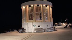 Un petit bâtiment illuminé, surmonté d’un dôme, doté de bancs et d’un panneau indiquant qu’il s’agit d’un point de vue.