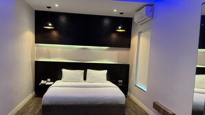 A modern hotel room with a large bed, two bedside tables, a nightstand, and a window. - Riivana Leisure Tavern (Lekki)