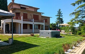 A two-story house with a covered patio, a swimming pool, and a sauna.