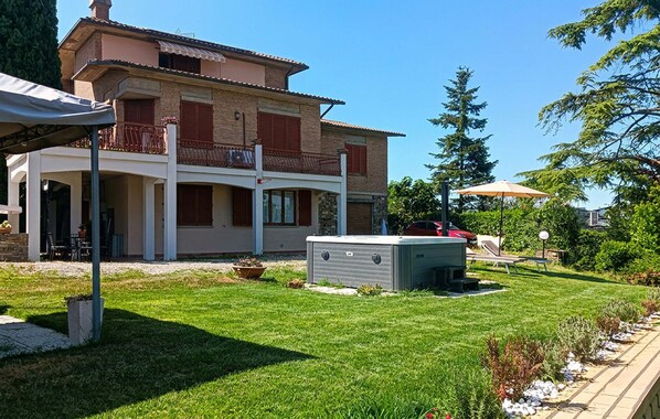 A two-story house with a covered patio, a swimming pool, and a sauna.