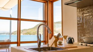 A kitchen with a large window, a stainless steel sink, and a view of the sea. - Setouchi Hideaway Resort (Onomichi)