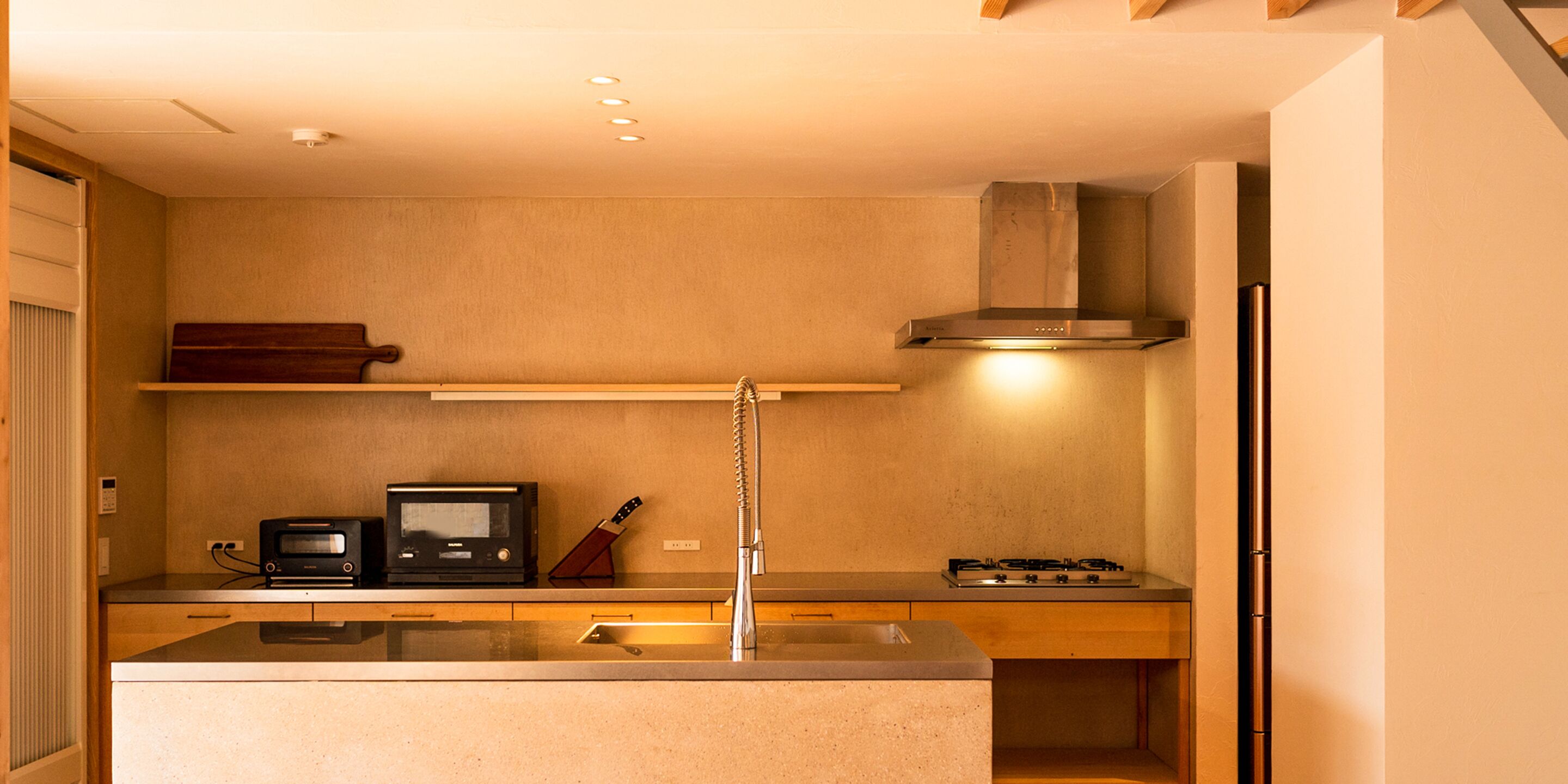 A compact kitchen with a built-in microwave, stove, and a knife block on the countertop.