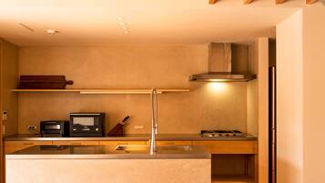 A compact kitchen with a built-in microwave, stove, and a knife block on the countertop.