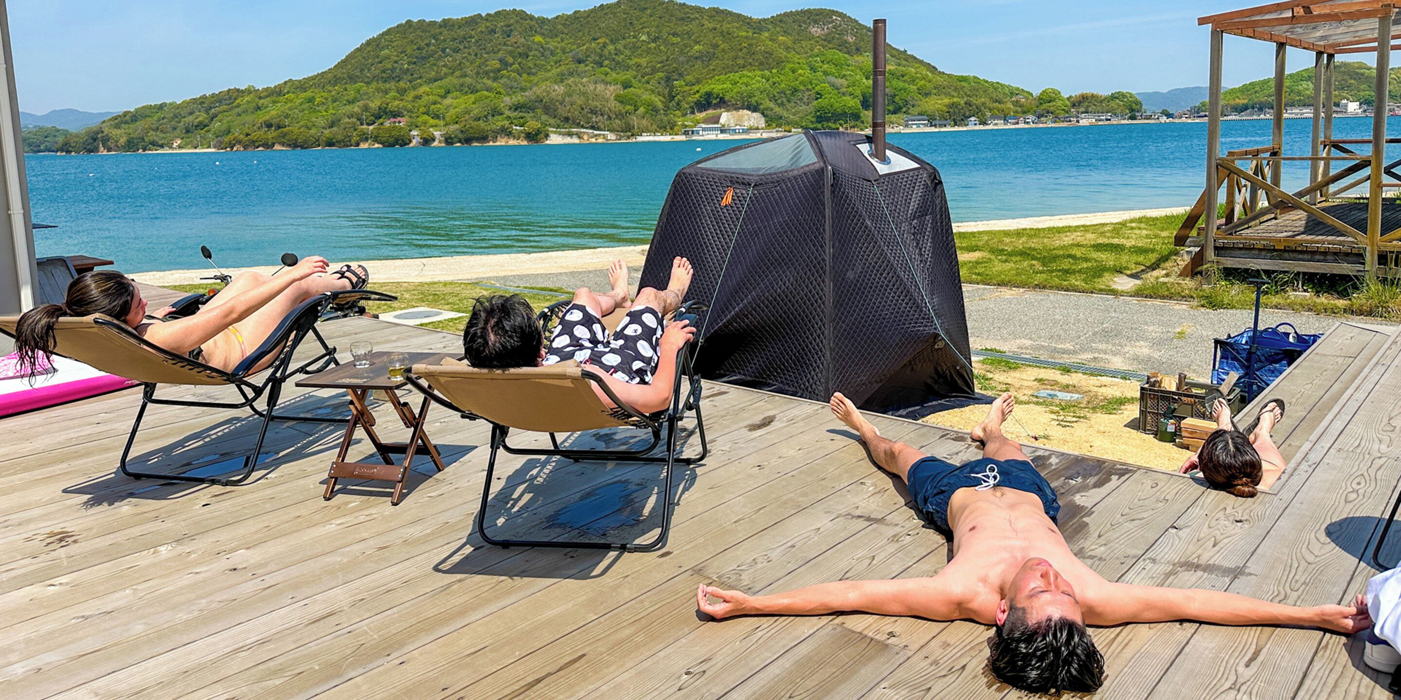 A wooden deck with lounge chairs and a barbecue grill.