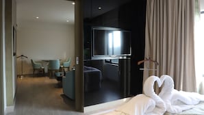 A hotel room with a bed, a TV, a desk, and chairs.