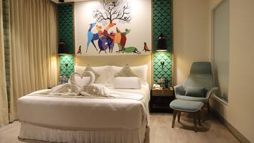 A bedroom with a large bed, a chair, a nightstand, and a wall mural.
