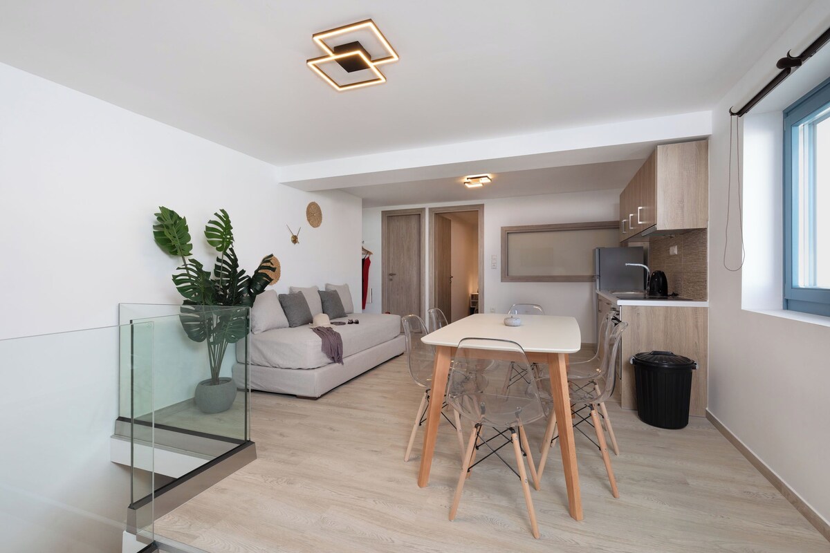 A modern apartment with a dining area, kitchen, and living space.