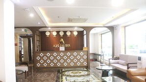 Eine Hotelrezeption im modernen Stil, mit einer Rezeption, einer Sitzecke und Blick ins Freie.