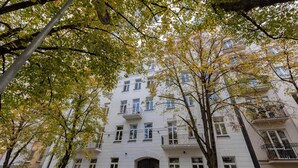 Un immeuble à plusieurs étages, doté d’une façade blanche, de nombreuses fenêtres et de balcons.