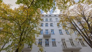 Un immeuble à plusieurs étages doté d’une façade symétrique, de grandes fenêtres et de balcons.