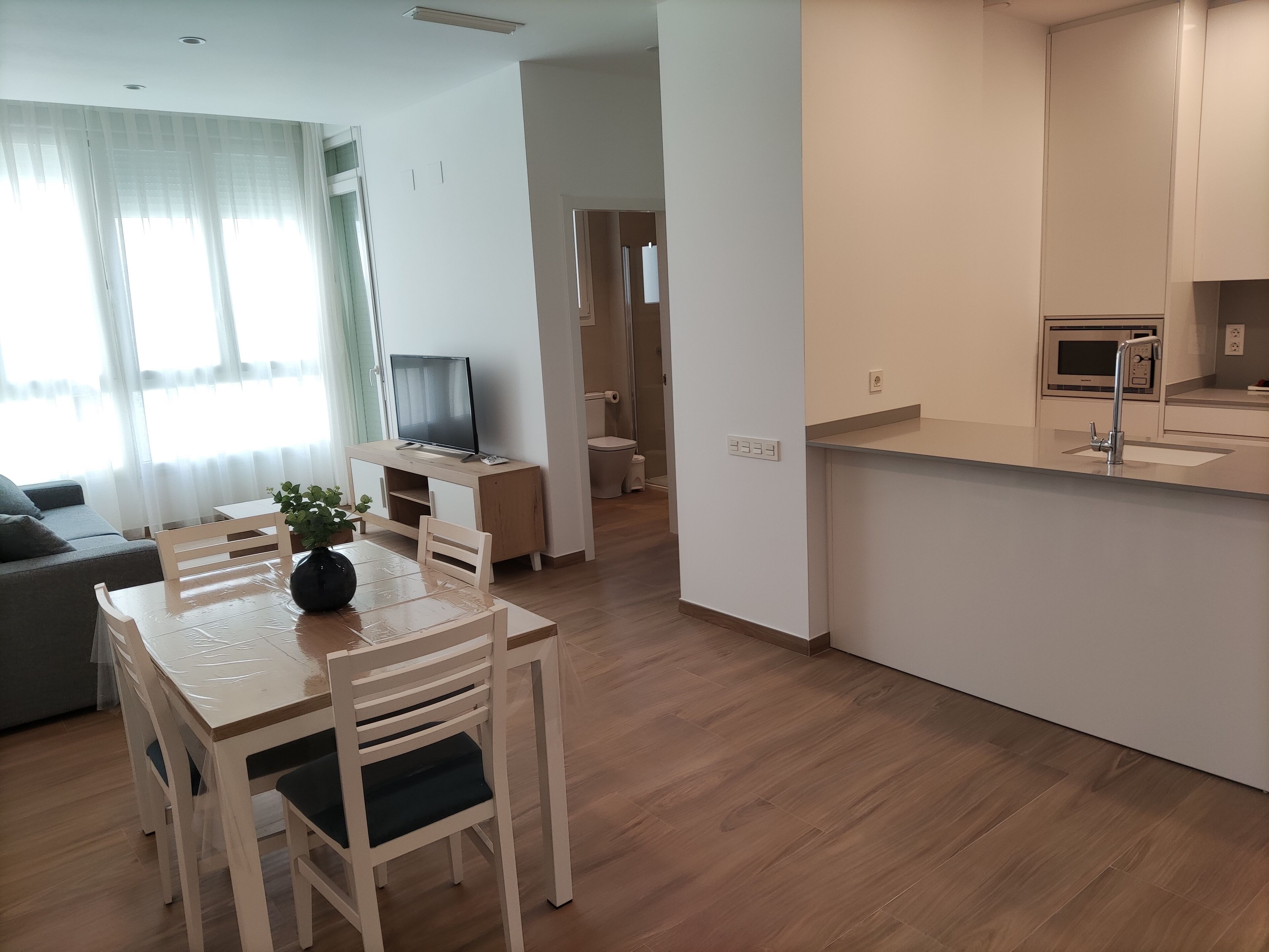 A modern apartment with a dining area, kitchen, and living room.