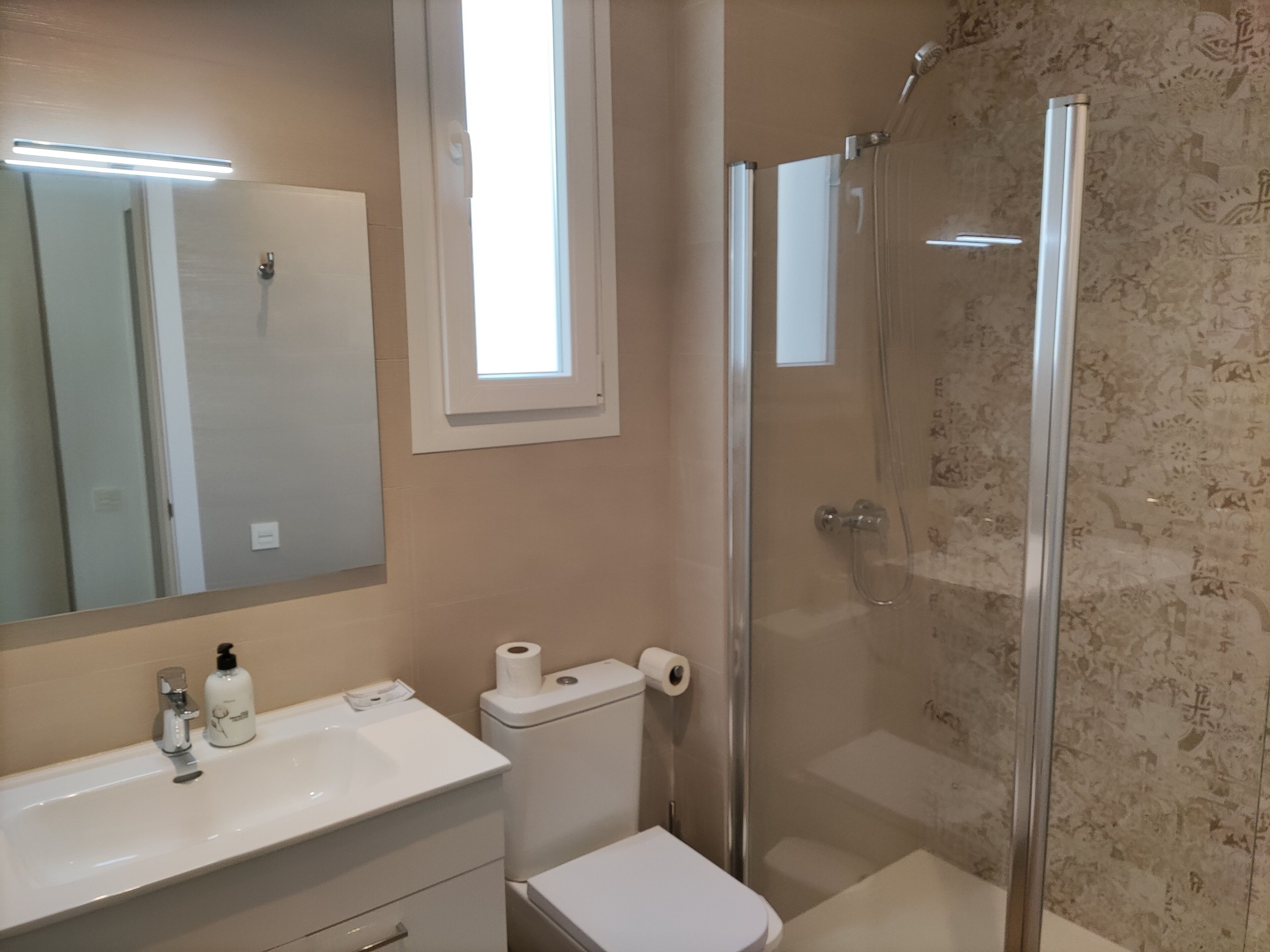 Een badkamer met toilet, wastafel en douche.