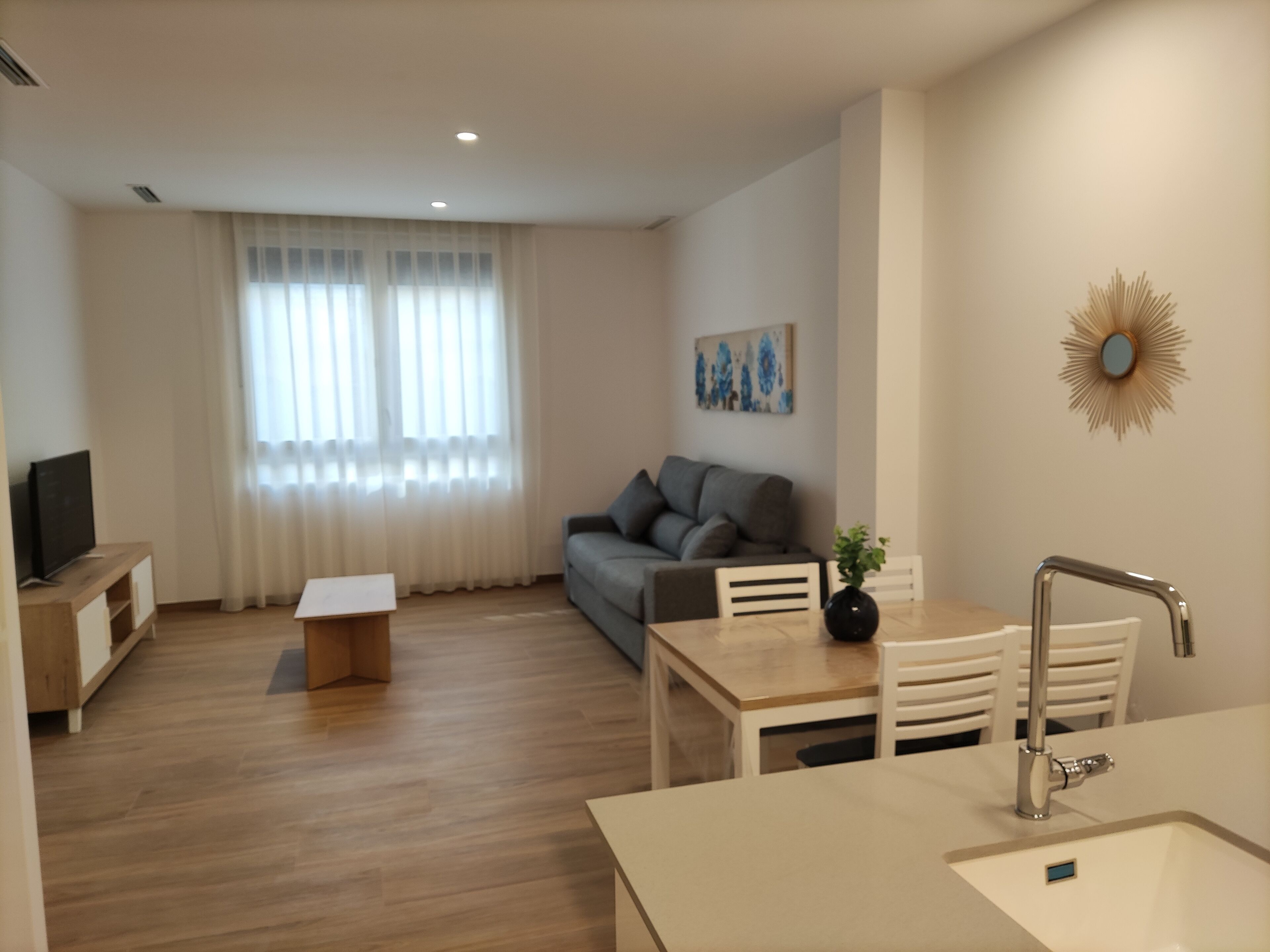 A modern living room with a sofa, a coffee table, and a TV.