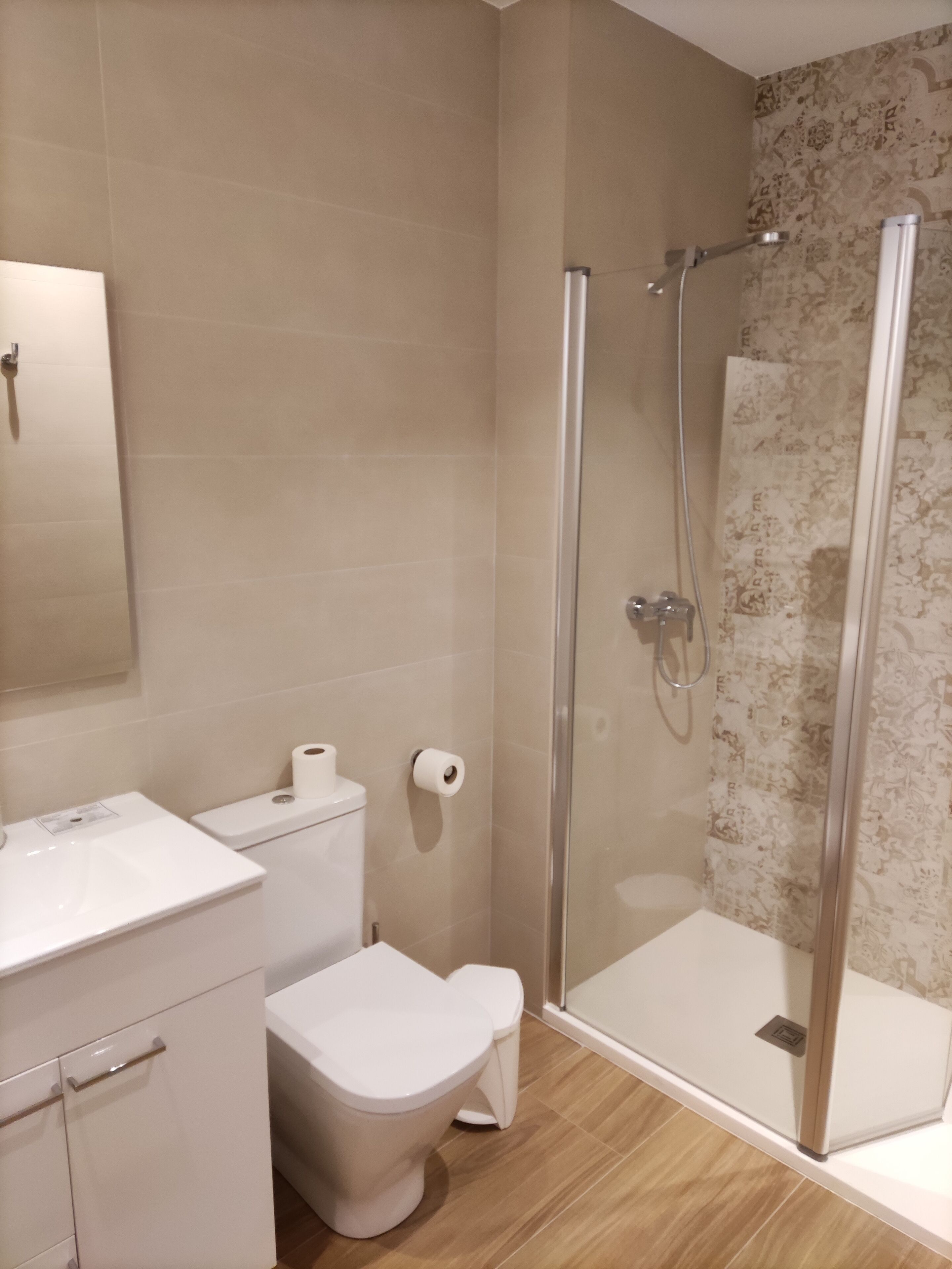A bathroom with a toilet, a sink, and a shower with a glass door.