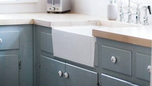 A kitchen with a toaster, a sink, and a window with curtains. - Cozy Millbrook Cottage | Pool Access Near Capitol (Millbrook)