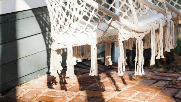 Two white macrame hammocks hanging from a porch. - Cozy Millbrook Cottage | Pool Access Near Capitol (Millbrook)