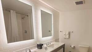 A modern bathroom with a double sink, large mirrors, a toilet, and a trash bin. - Comfort Inn & Suites Panama City Beach - Pier Park Area (Panama City Beach)