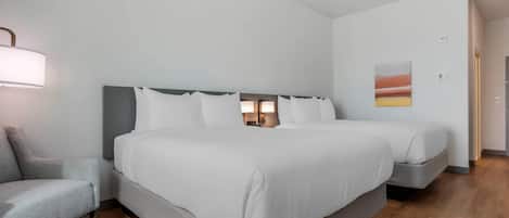 Habitación de hotel con una cama grande, una mesita de noche, una lámpara y un cuadro en la pared.