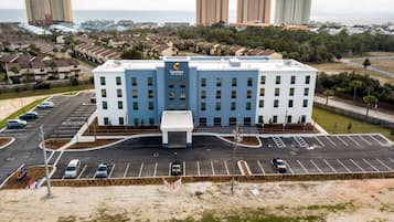 Hotel con entrada principal, estacionamiento y zona residencial circundante.