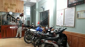 Une salle d'attente avec un comptoir, une horloge et plusieurs motos garées au fond.