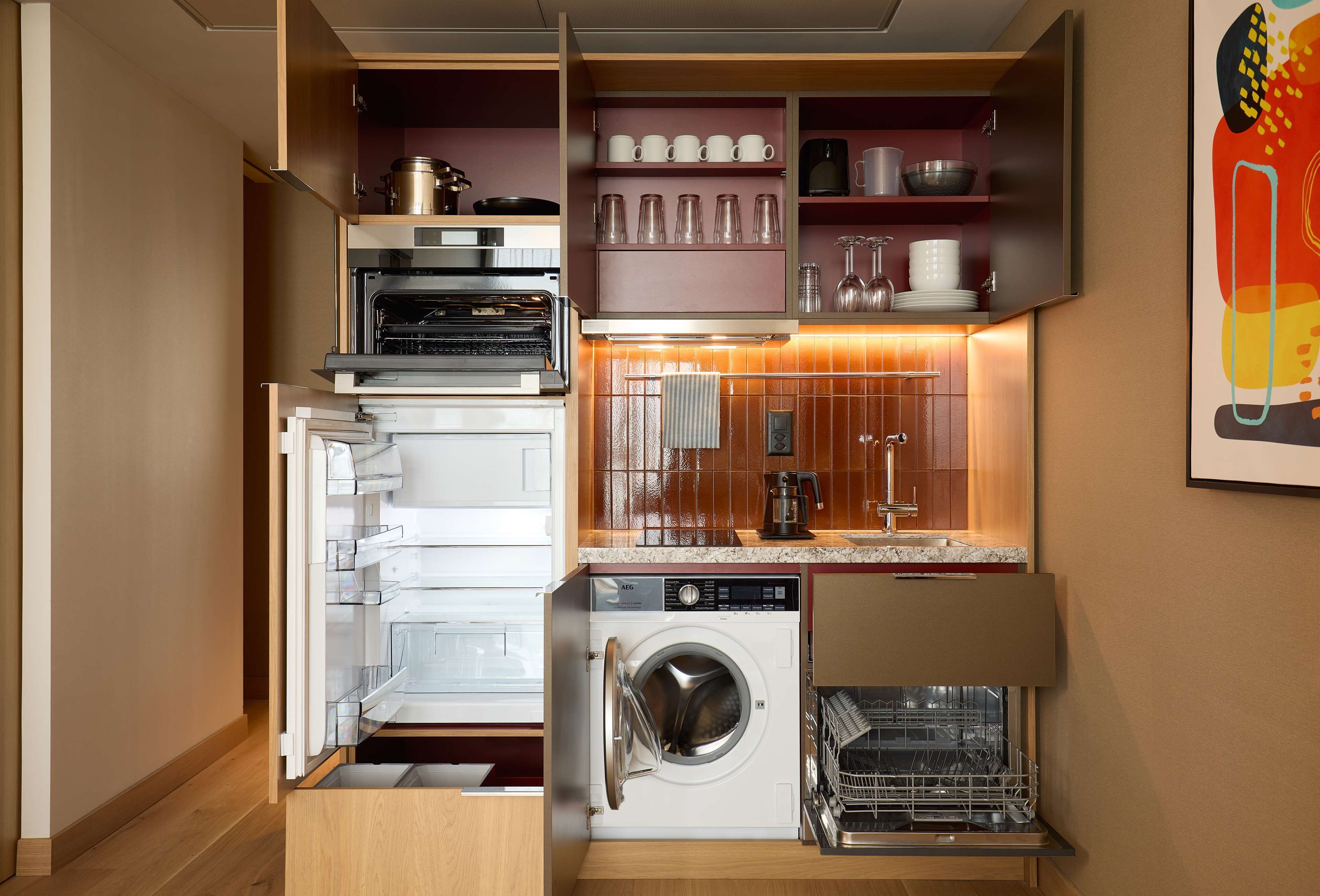 A compact kitchen with a built-in oven, microwave, and dishwasher.