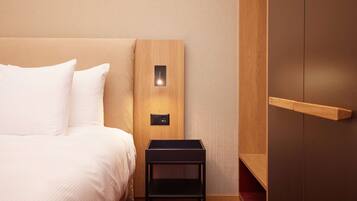 A hotel room with a bed, a nightstand, a wooden panel wall, and a wardrobe.