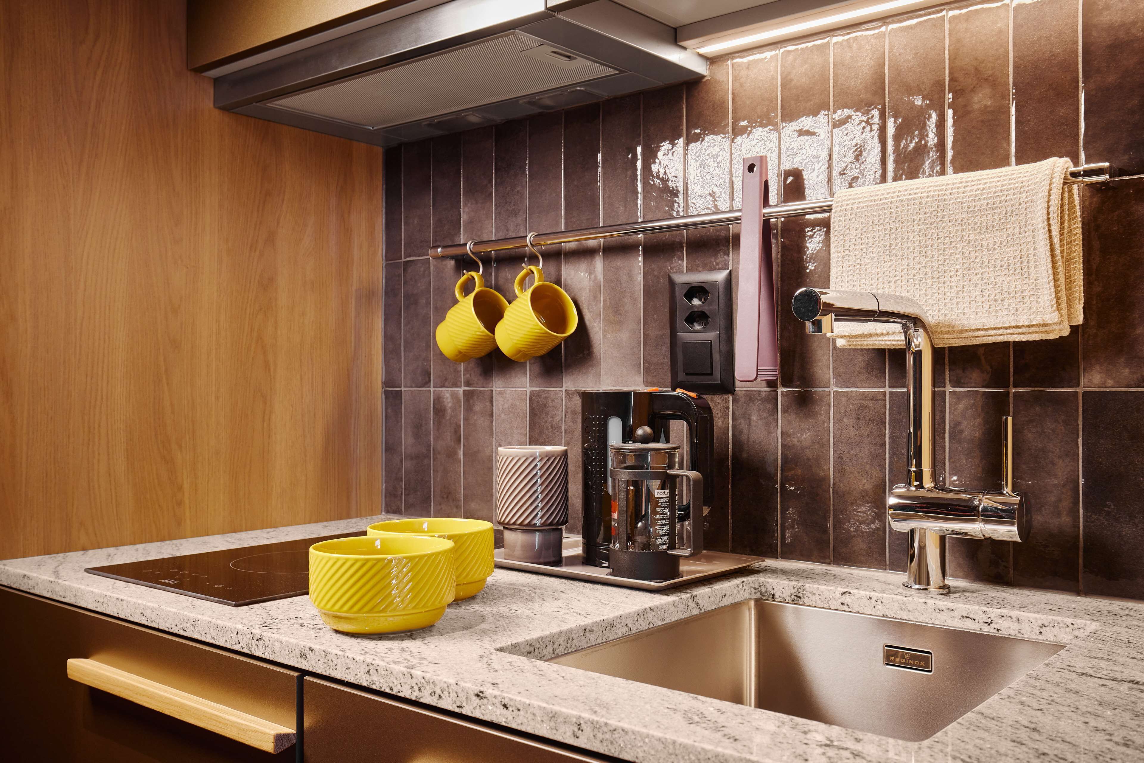 A modern kitchen with a double sink, stainless steel faucet, and a coffee maker.