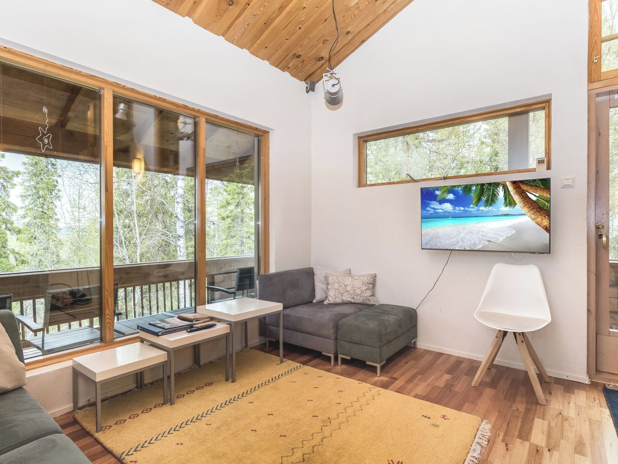 Una sala de estar moderna con sofá, mesa de centro y televisor montado en la pared.