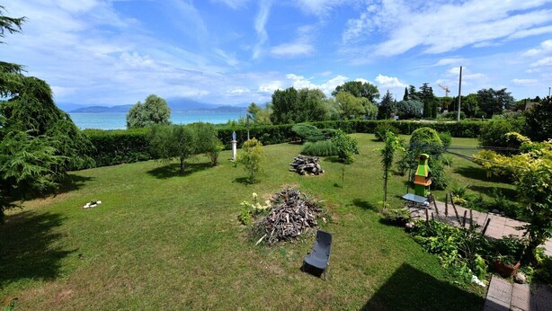 Un jardin bien entretenu, avec une pelouse, des arbres et une petite statue.