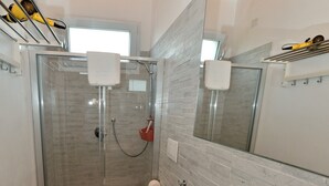 Une salle de bain moderne avec une douche à parois de verre, des toilettes et un lavabo avec un miroir au-dessus.