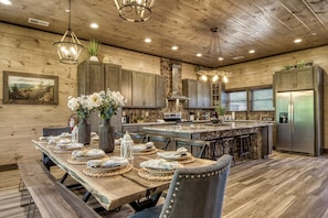 A spacious kitchen with wooden walls, a large island, and modern appliances.
