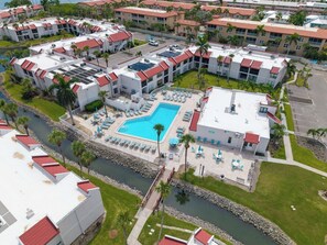 Een resort met meerdere gebouwen, een centraal zwembad en een rivier.