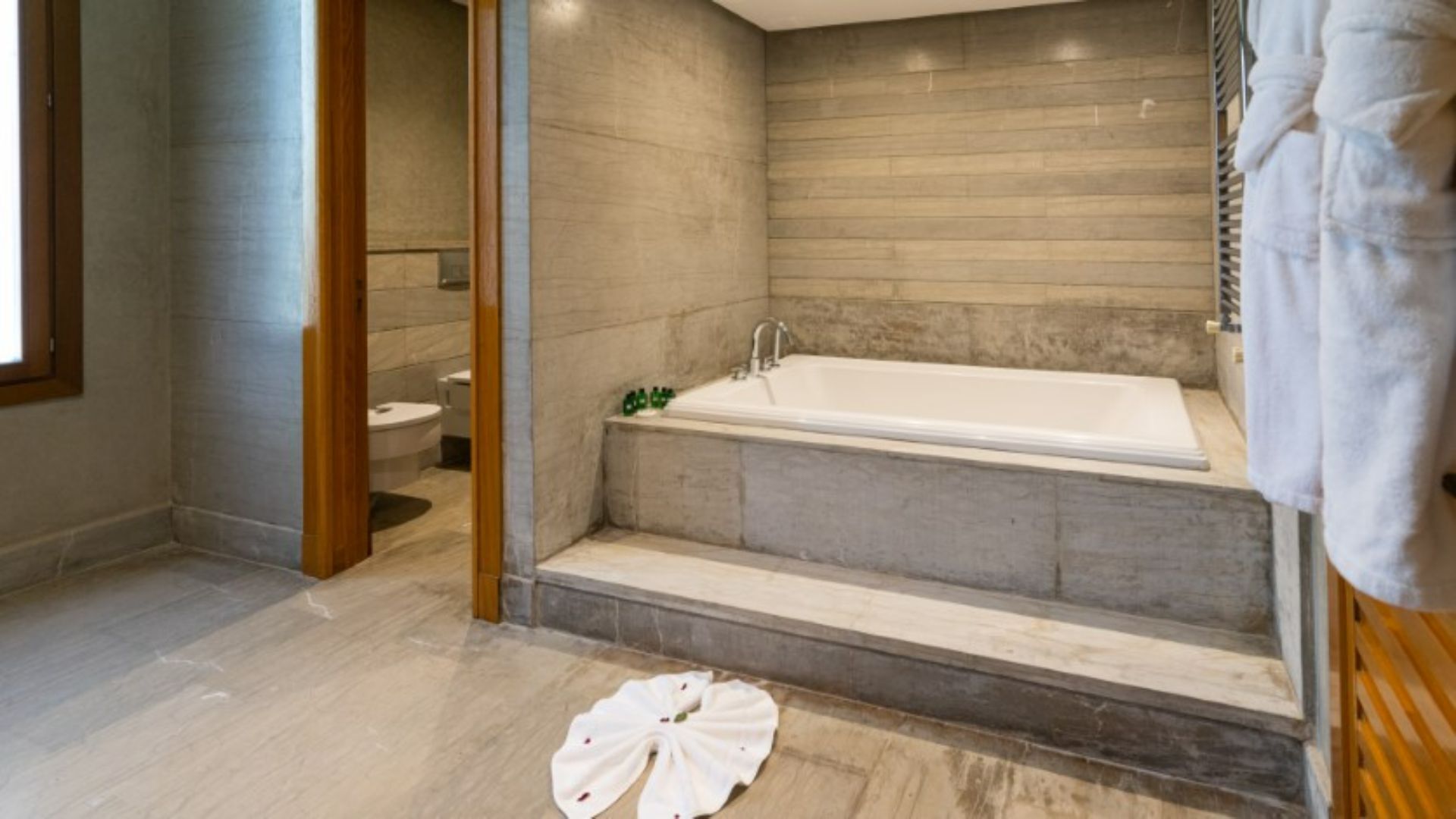 A modern bathroom with a freestanding bathtub, a toilet, and a shower area.