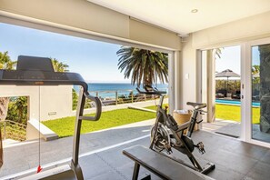 A home gym with exercise equipment and a view of the ocean.