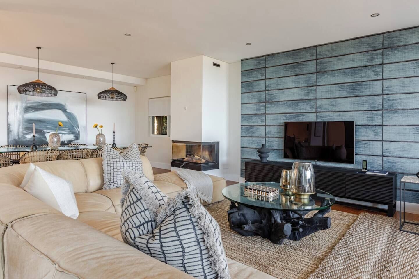 A modern living room with a sofa, coffee table, and a fireplace.