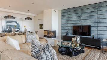 A modern living room with a sofa, coffee table, and a fireplace.