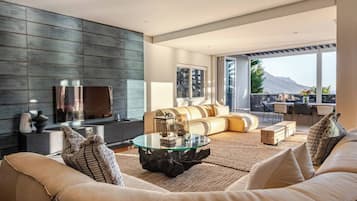 Un salon moderne avec un canapé, une table basse et un téléviseur.