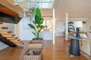Un interior moderno con una escalera, un comedor y un área de estar.