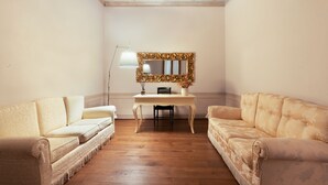Une pièce avec deux canapés, une table et un miroir.