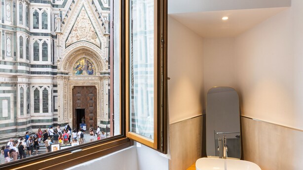 Une salle de bain avec une grande fenêtre, un lavabo et un miroir.