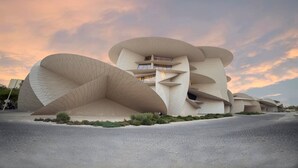 Un edificio de arquitectura moderna con un diseño curvo único, que cuenta con varios niveles y un espacio abierto central.