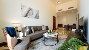 Una sala de estar moderna con un sofá gris, una mesa de centro y un televisor.