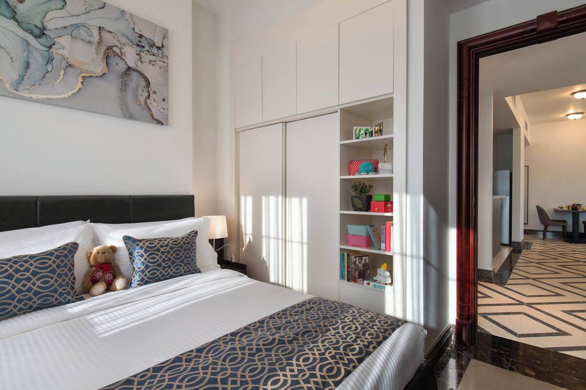 A neatly arranged bedroom with a bed, bedside table, and a wardrobe.