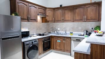 A modern kitchen with wooden cabinets, stainless steel appliances, and a granite countertop.