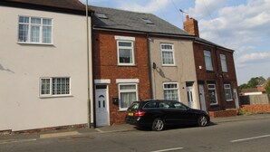 A two-story residential building with a black car parked in front. - St Anns House (Rotherham)