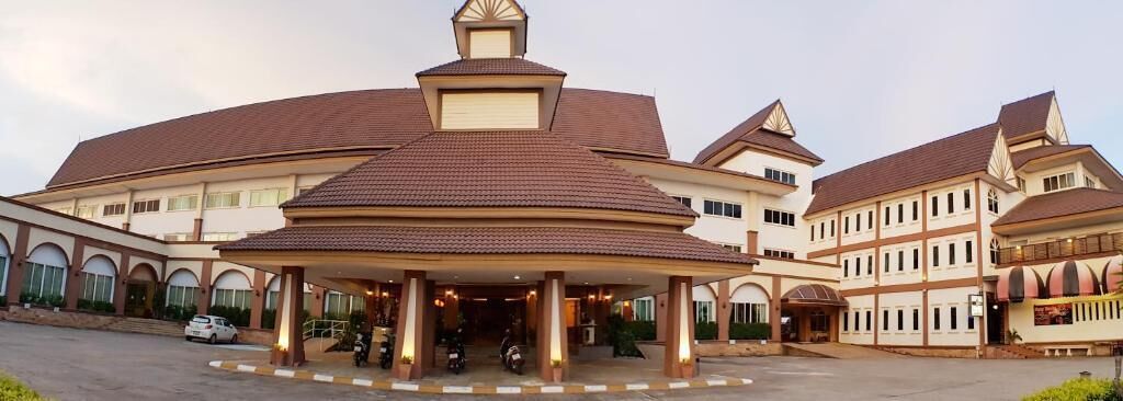 Un hotel grande de varios pisos con una cúpula central y un vestíbulo cubierto.
