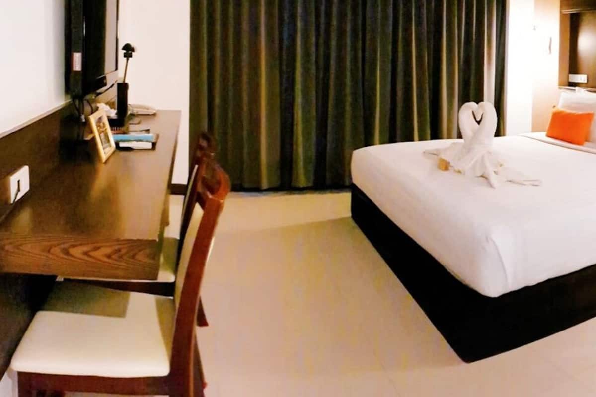 Ein Hotelzimmer mit einem großen Bett, einem Schreibtisch und einem Stuhl.
